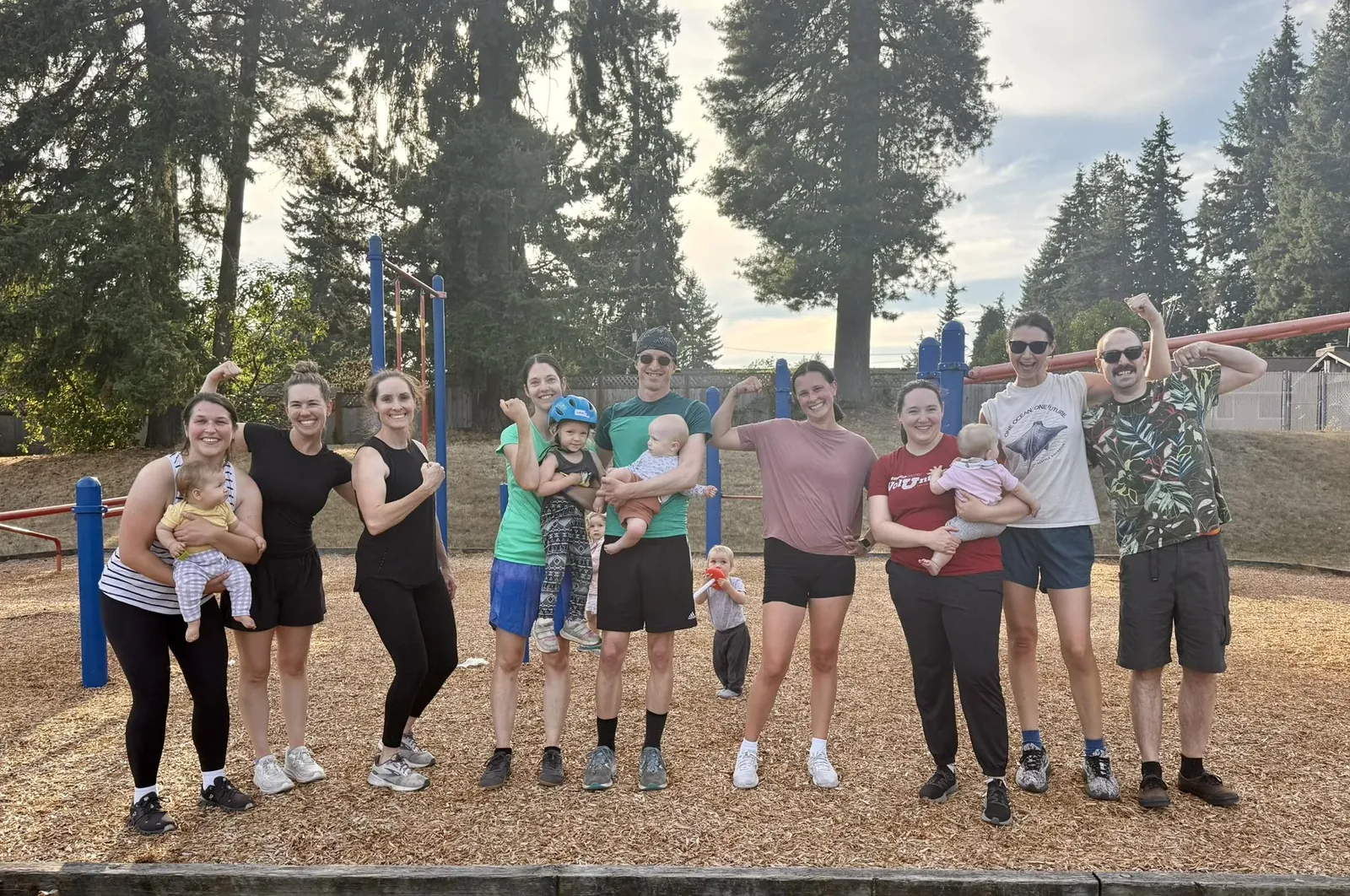 Two dads working out with dumbbells at an outdoor class